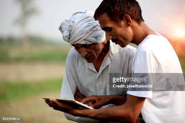 agronomist consulting with farmer outdoor in the field - village stock pictures, royalty-free photos & images