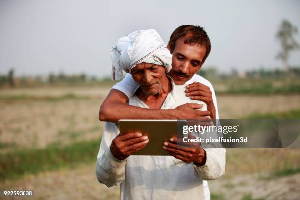 father & son using tablet computer - developing countries technology stock pictures, royalty-free photos & images
