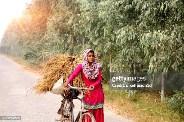 donne indiane in bicicletta su strada di campagna - indian female feet foto e immagini stock