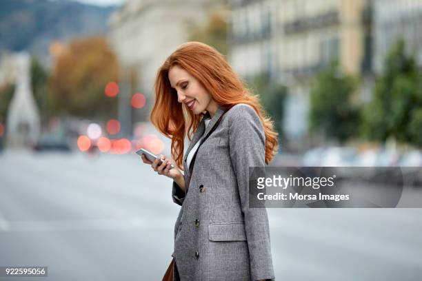 城市中使用智慧手機的紅發女郎 - blazer 個照片及圖片檔