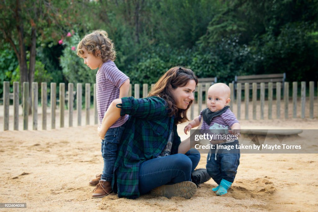 Mum busy playing with babies at the playground