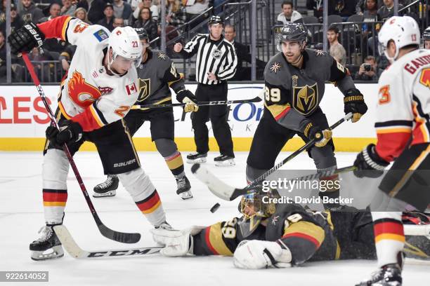 Alex Tuch defends as his teammate goalie Marc-Andre Fleury of the Vegas Golden Knights makes a save against Sean Monahan of the Calgary Flames during...