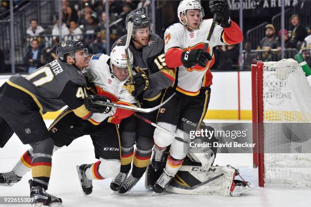 Ryan Carpenter and Jon Merrill of the Vegas Golden Knights skate to the puck against Micheal Ferland and Mark Jankowski of the Calgary Flames during...