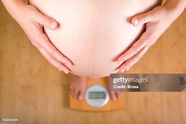 pregnant and scale - woman weight scale stock pictures, royalty-free photos & images