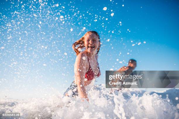 couple enjoying and having fun in the sea - australian summer stock pictures, royalty-free photos & images