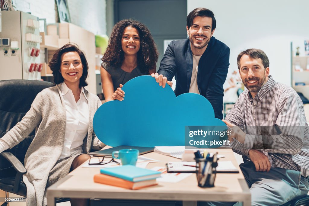 Alegre equipo de profesionales con una gran nube azul