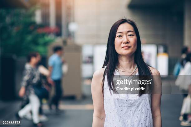 japanerin im freien in der stadt - mature women portrait asian stock-fotos und bilder