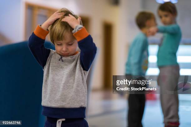 small cute boy is sad because the other kids gossip him - social exclusion stock pictures, royalty-free photos & images