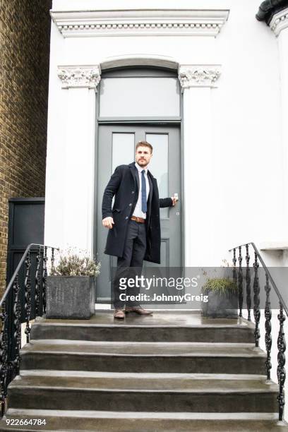 mid adult  businessman closing front door and standing outside house - closes stock pictures, royalty-free photos & images