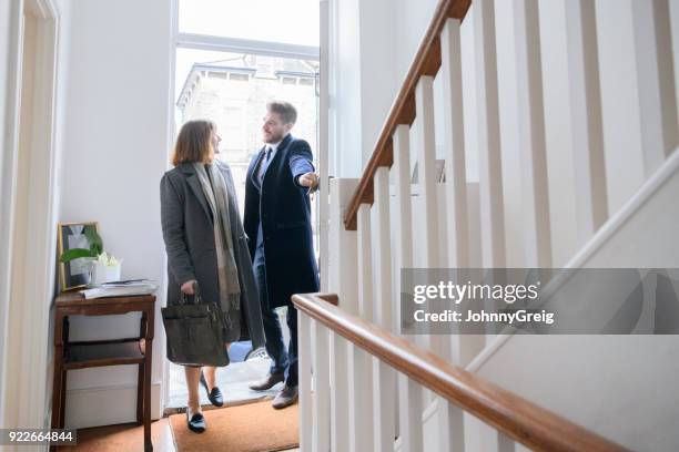 medio pareja adultos llegar a casa después del trabajo y entrar en el pasillo - caballerosidad fotografías e imágenes de stock