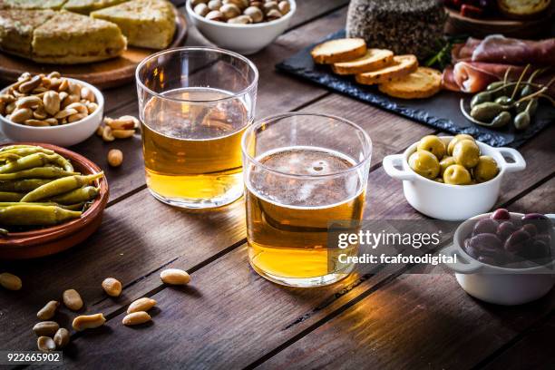 cerveza y tapas en rústica mesa de madera - aperitivo plato de comida fotografías e imágenes de stock