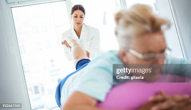 senior woman in a massage treatment. - varicose vein stock pictures, royalty-free photos & images