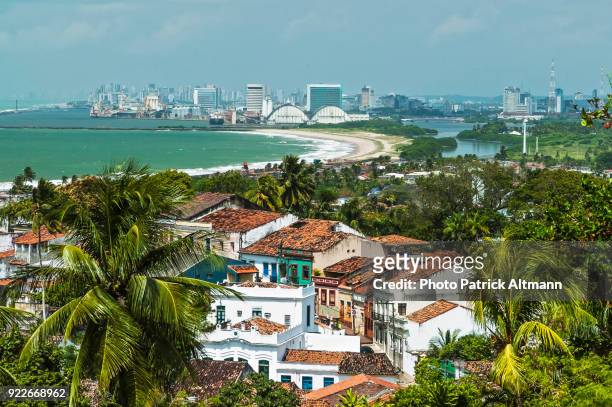 old houses on unesco world heritage site in a tropical environment surrounded by palm trees. in contrast with a modern city on seaside that appears in the background. olinda, pernambuco, brazil - olinda fotografías e imágenes de stock