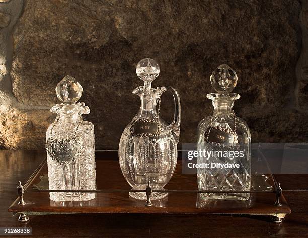 verschiedene antikem glas dekantierkaraffen auf hölzernen tablett - kristallglas stock-fotos und bilder