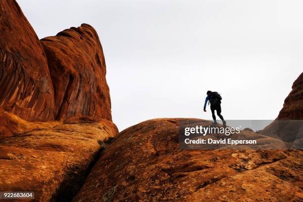 woman hiking in fiery furnace area of arches national park in winter. - fiery furnace arches national park stock pictures, royalty-free photos & images