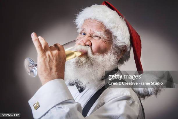 santa claus drinking a glass of champagne to celebrate - retirement invitation stock pictures, royalty-free photos & images