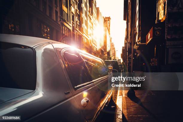 white limousine parking on street in midtown manhattan - limousine photos et images de collection