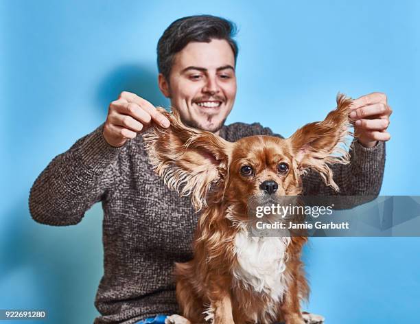 playful studio portrait of early 30's male and his dog - cute dog with man stock pictures, royalty-free photos & images