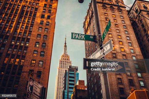 urban skyline in midtown manhattan with distant view of empire state building - 5th avenue sign stock pictures, royalty-free photos & images