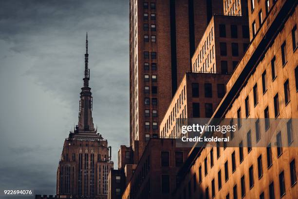 urban skyline in midtown manhattan with distant view of empire state building - empire state building stock pictures, royalty-free photos & images