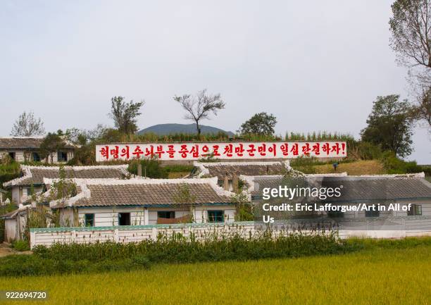 North Korean propaganda billboard in front of houses in a village, South Hamgyong Province, Hamhung, North Korea on September 11, 2012 in Hamhung,...