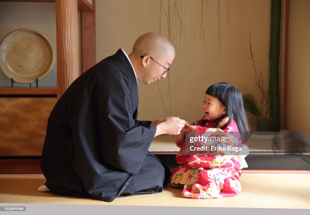 Father giving New Year's gift of money called otoshidama to daughter