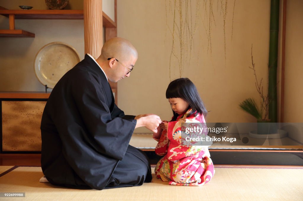 Father giving New Year's gift of money called otoshidama to daughter