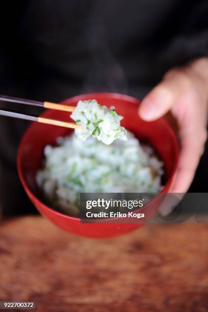 man eating rice porridge with seven herbs of spring called nanakusa gayu - daily life in kyoto stock-fotos und bilder