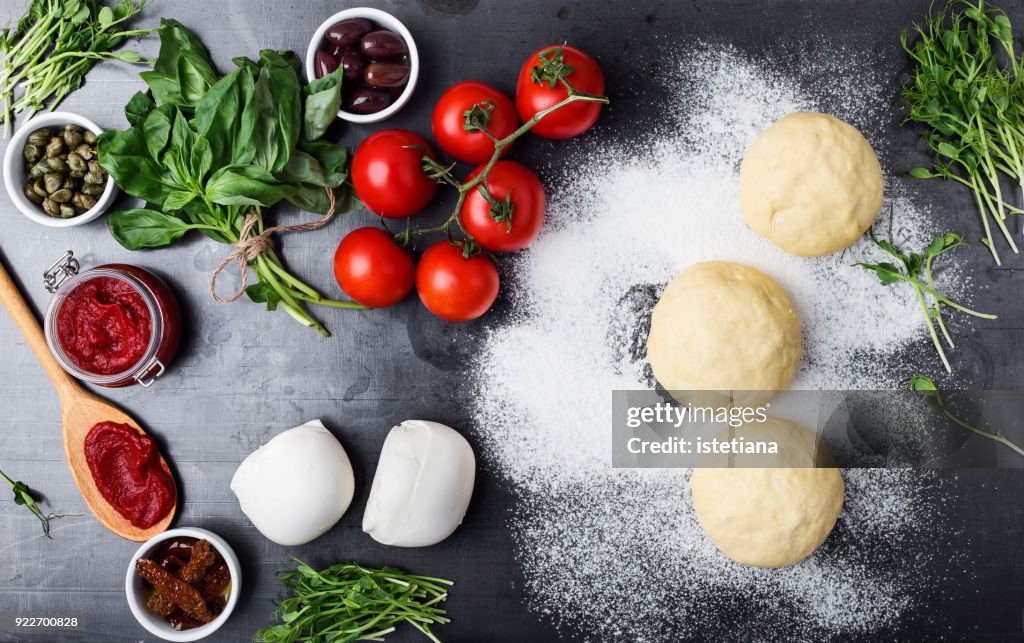 Raw pizza dough with ingredients
