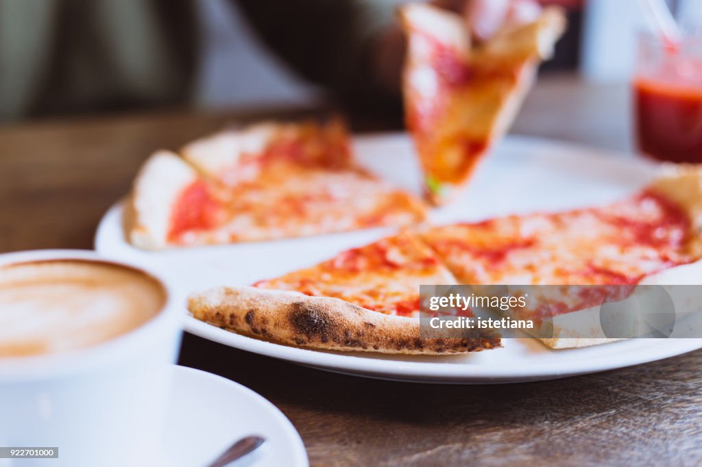 Pizza time. Person enjoying pizza in restaurant