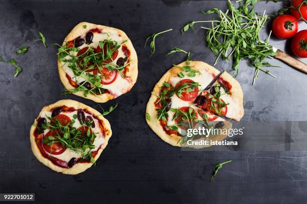 homemade gourmet  mini pizza with tomatoes and green pea sprouts topping - pizza ingredients stock pictures, royalty-free photos & images