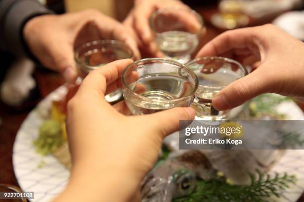 family making toast with sake over sashimi of squid - 飲み会　日本 ストックフォトと画像