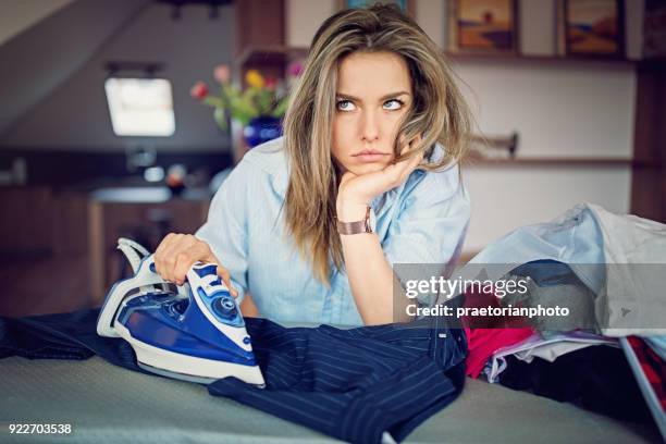 ragazza annoiata sta stirando senza desiderio - ferro da stiro foto e immagini stock