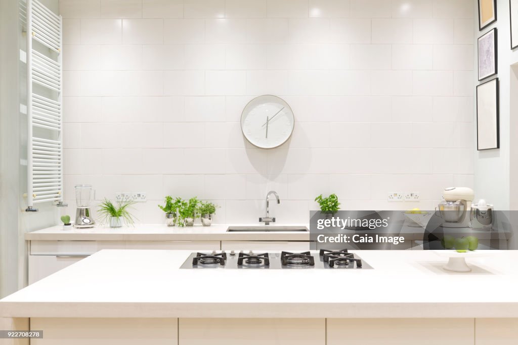 White, modern luxury home showcase interior kitchen with clock