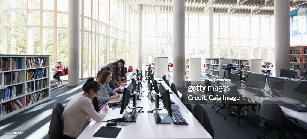 Students researching at computers in library