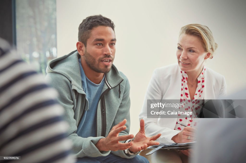 Young man talking in group therapy session