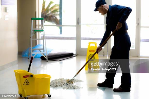 full length image of senior man working as a janitor in building. - mop up stock pictures, royalty-free photos & images