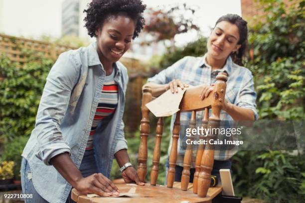 Women friends sanding, refinishing chair