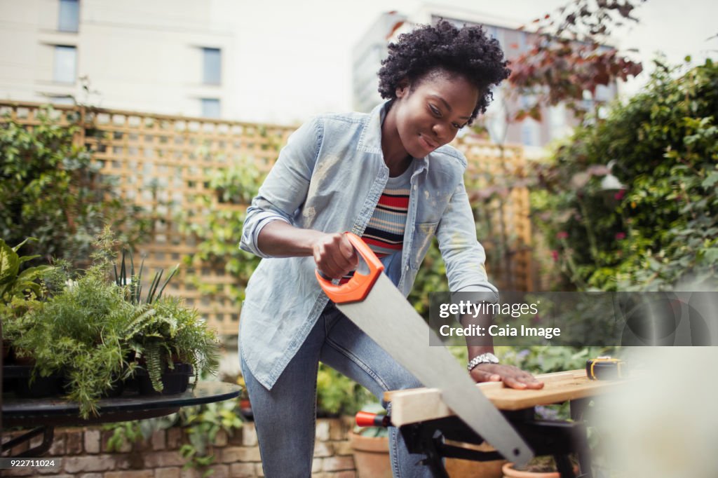 Woman with saw cutting wood