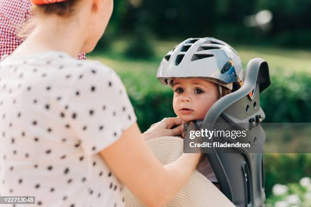 mother putting a helmet on her son's head - saddle stock pictures, royalty-free photos & images