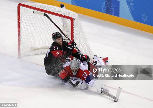 Mat Robinson of Canada collides with Pavel Francouz of the Czech Republic in overtime during the Men's Ice Hockey Preliminary Round Group A game on...