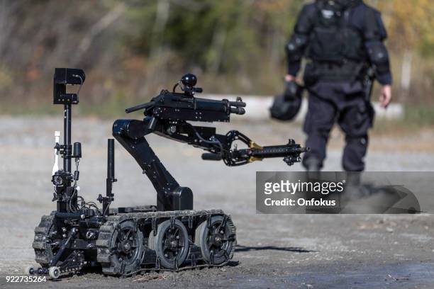 polizei swat officer mit einem mechanischen arm bombe roboter abfallbehälter - sprengkapsel stock-fotos und bilder