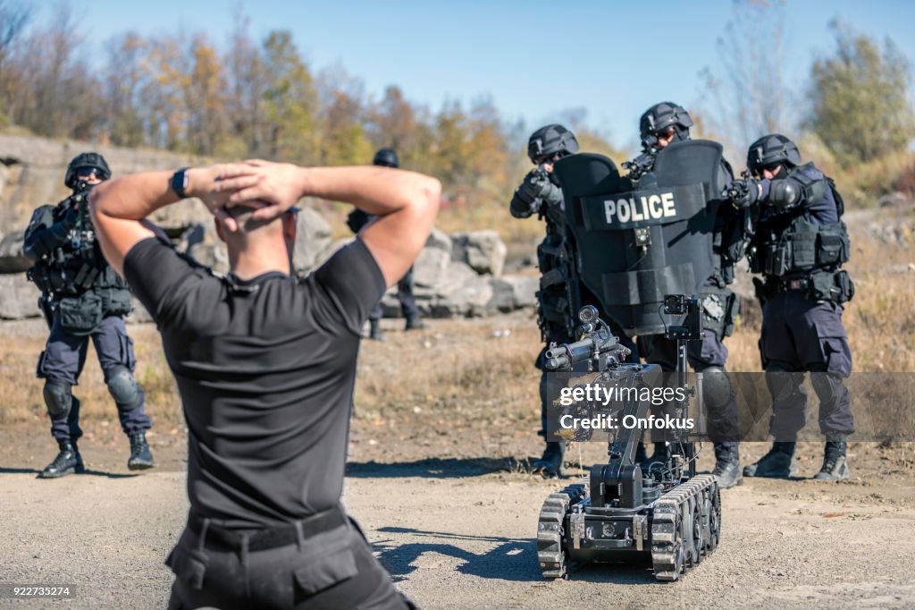 Policía Swat oficiales de equipo utiliza una unidad de Robot mecánico
