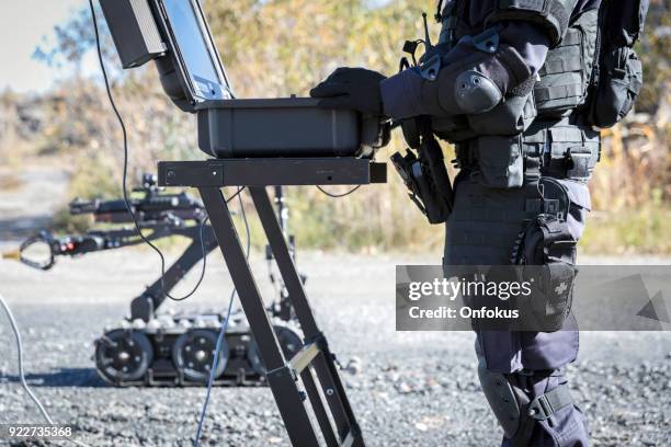 polizei swat officer mit einem mechanischen arm bombe roboter abfallbehälter - bombenentschärfer stock-fotos und bilder
