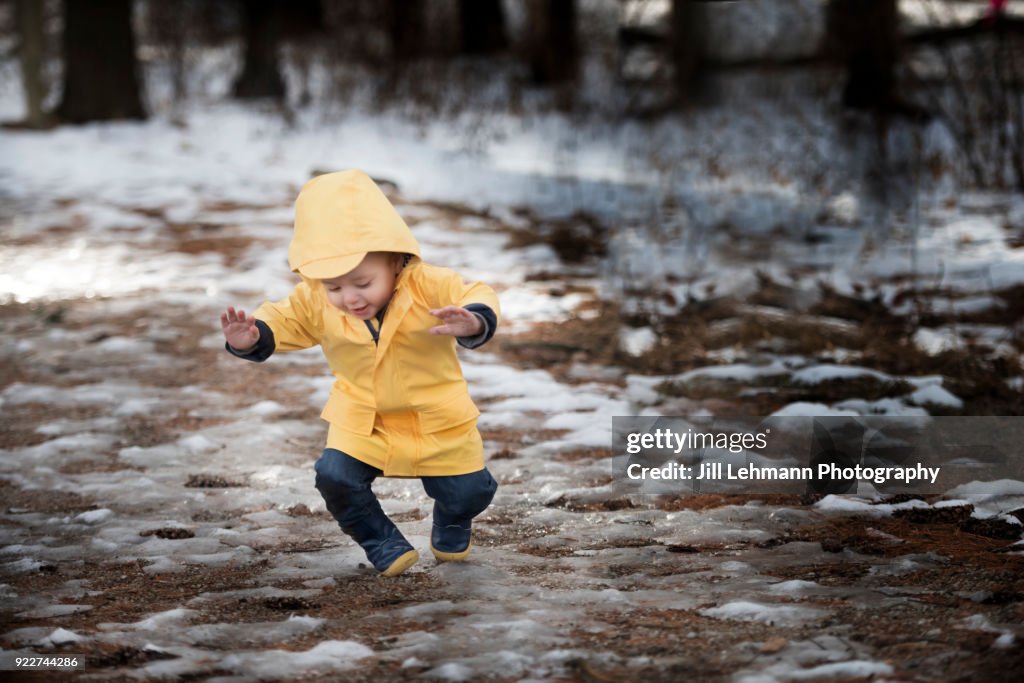 19 Month Old Male Toddler in Yellow Rain Jacket Falls on Snow and Ice in the Woods