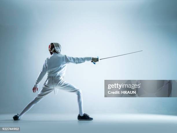 teenage fencer standing in lunge position - fechten stock pictures, royalty-free photos & images