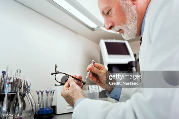 optician in workshop - optical manufacturing stock pictures, royalty-free photos & images