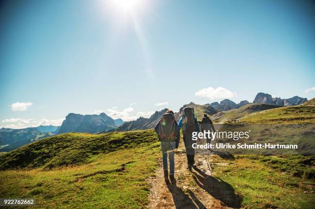 father with two teenage children hiking in the alps - escursionismo foto e immagini stock