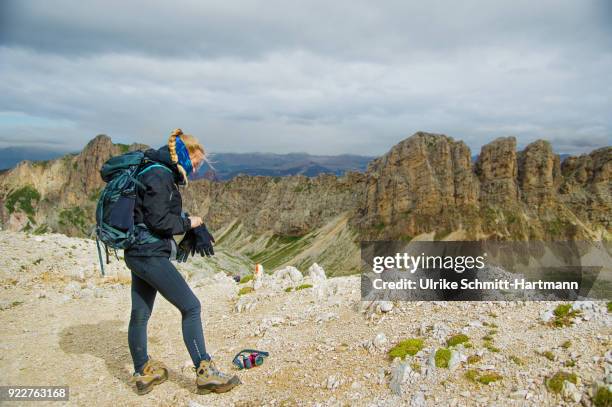 female teenage hiker in the alps, putting on glovesin cold weather - girl wearing boots stock pictures, royalty-free photos & images