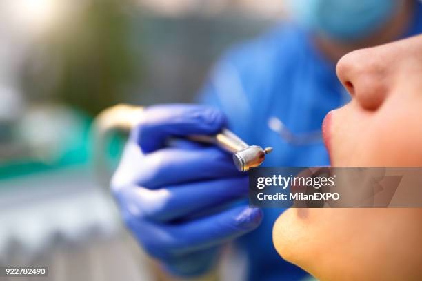 joven teniendo un procedimiento en la oficina de dentistas - dental fear fotografías e imágenes de stock